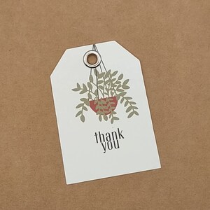 May include: White gift tag with a hanging plant illustration and the text "thank you".