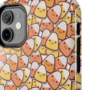 Puede incluir: Una funda de teléfono blanca con un patrón de maíz dulce naranja y amarillo con caras sonrientes.