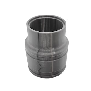 May include: A gray 3D printed plastic pipe connector with a split design.