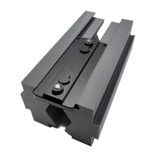 May include: A gray and black 3D printed mounting bracket with two black knobs. The bracket has a textured surface and is designed to be attached to a wall or other surface.