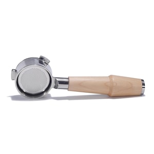 May include: A stainless steel espresso portafilter with a wooden handle. The portafilter has a single, round filter basket.