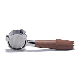 May include: A silver espresso portafilter with a wooden handle. The portafilter has a round, perforated basket.