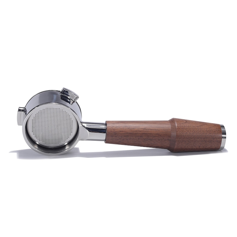 May include: A silver espresso portafilter with a wooden handle. The portafilter has a round, perforated basket.