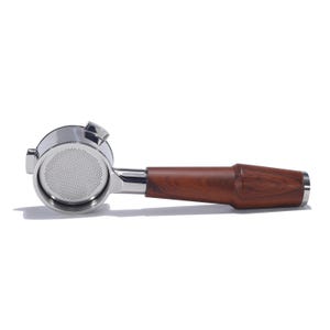 May include: A stainless steel espresso portafilter with a wooden handle. The portafilter has a single spout and a mesh filter basket.