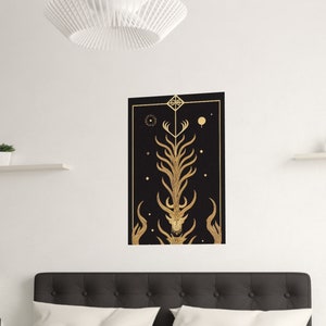 K&ouml;nnte beinhalten: Ein geometrischer Druck in Schwarz und Gold mit einem stilisierten Hirschkopf und Geweih. Der Druck ist gerahmt und h&auml;ngt an einer wei&szlig;en Wand &uuml;ber einem schwarzen Kopfteil.