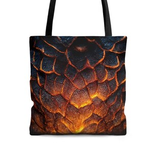 May include: A black tote bag with a design of orange and black lava rock. The design is a close-up of the rock's texture.