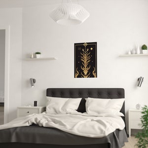 K&ouml;nnte beinhalten: Ein schwarzer und goldener Druck mit einem stilisierten Baumdesign. Der Baum hat einen Sch&auml;del an der Basis und ist von Sternen und Himmelsk&ouml;rpern umgeben. Der Druck ist gerahmt und h&auml;ngt an einer wei&szlig;en Wand &uuml;ber einem Bett.