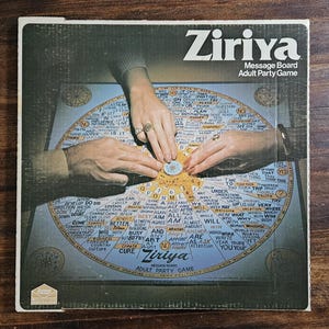 May include: A vintage board game box titled "Ziriya Message Board Adult Party Game." The box features a circular game board with text and hands interacting with the game pieces. The game board is blue and gold.