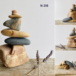 Puede incluir: Una escultura de equilibrio de piedras hecha con piedras de varios tama&ntilde;os y colores. La escultura est&aacute; equilibrada sobre una superficie de madera con espigas de lavanda secas. La imagen tambi&eacute;n muestra vistas de cerca de la escultura desde diferentes &aacute;ngulos.