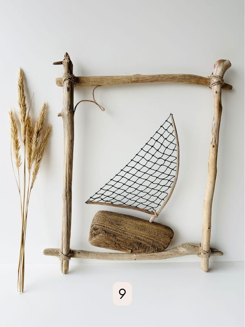 May include: A driftwood sailboat with a black net sail and a wooden base is framed by a rustic wooden structure. Dried wheat stalks are on the left. The number 9 is in a white square at the bottom.