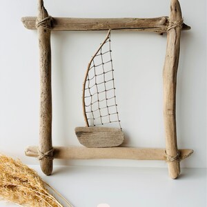 Handmade driftwood wall hanging with sailboat design, nautical coastal wall decor made from natural wood, rope, and netting