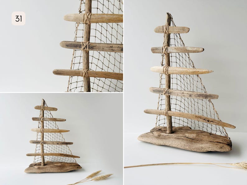 Puede incluir: Escultura de velero de madera flotante con acabado de madera natural. La escultura presenta un m&aacute;stil de madera con listones horizontales de madera y una vela de red. La base es un trozo de madera flotante. El n&uacute;mero "31" est&aacute; en la esquina superior izquierda.