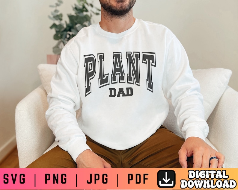 May include: A white long-sleeved sweatshirt with the text "PLANT DAD" in black letters.