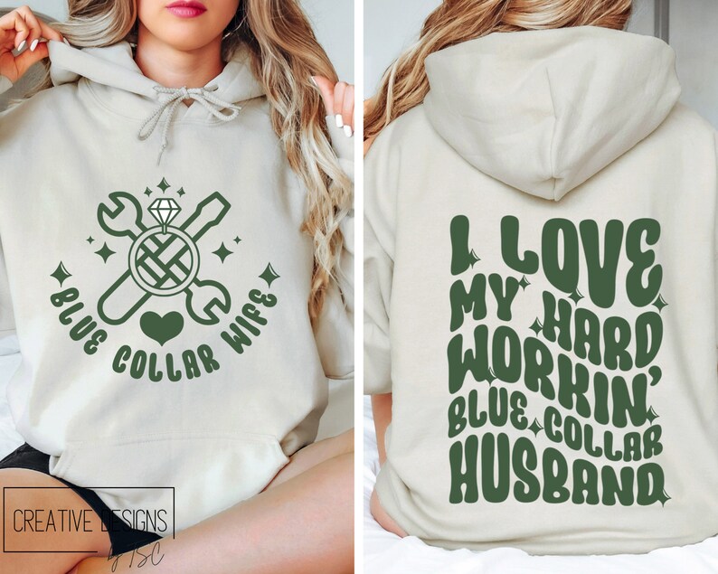 May include: A light beige hoodie with a green design on the front that says "Blue Collar Wife" with a wrench, screwdriver, and diamond ring. The back of the hoodie has a green design that says "I Love My Hard Workin' Blue Collar Husband".