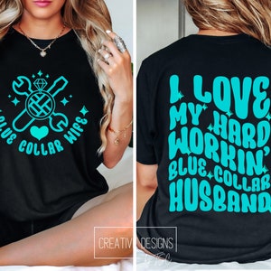 May include: A black t-shirt with a turquoise design on the front that says "Blue Collar Wife" with a wrench, screwdriver, diamond ring, and heart. The back of the shirt has a turquoise design that says "I Love My Hard Workin' Blue Collar Husband".