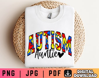 May include: White sweatshirt with the text "AUTISM Auntie" in blue, red, and yellow puzzle pieces. The word "Auntie" is in black with a black heart.