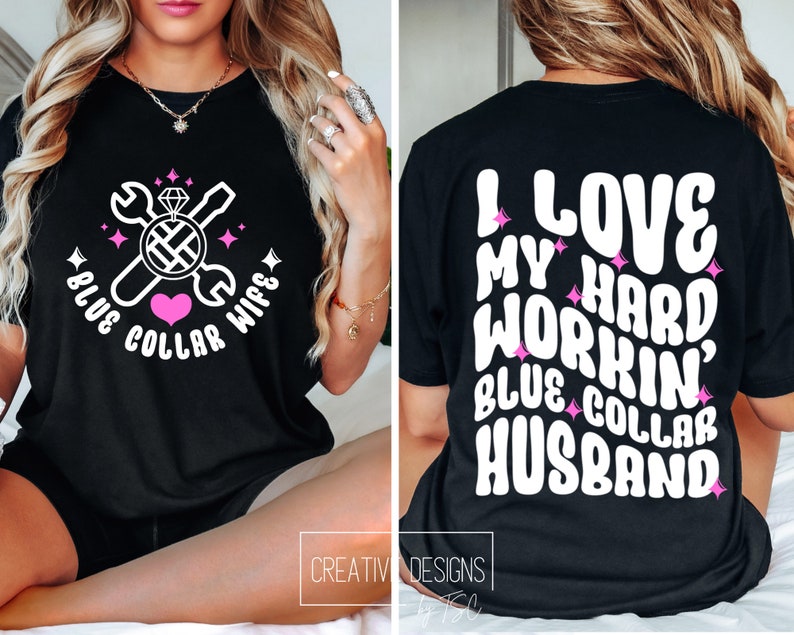 May include: Black t-shirt with a white graphic design featuring a wrench, screwdriver, diamond ring, and heart. The text reads "Blue Collar Wife". The back of the shirt has white text that reads "I Love My Hard Workin' Blue Collar Husband".