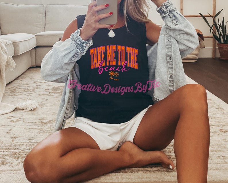 K&ouml;nnte beinhalten: Ein schwarzes &auml;rmelloses Tanktop mit dem Text "Take Me To The Beach" in rosa und orangefarbener Schrift. Der Text ist von Palmen und einer Wellengrafik umgeben. Das Tanktop wird von einer Person getragen.
