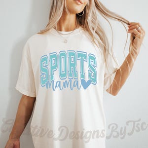 May include: A white t-shirt with the text "SPORTS mama" in blue and teal lettering with a blue heart.