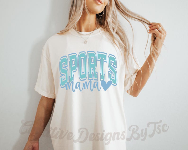 May include: A white t-shirt with the text "SPORTS mama" in blue and teal lettering with a blue heart.
