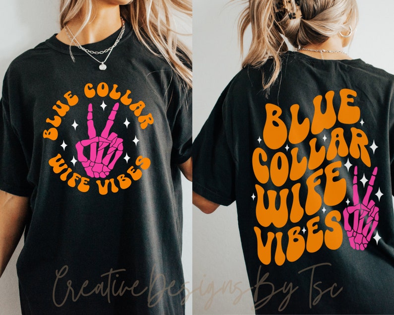 May include: Black t-shirt with an orange graphic that says "Blue Collar Wife Vibes" with a pink skeleton hand making a peace sign.