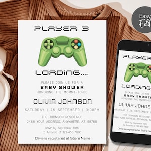 May include: A white rectangular baby shower invitation card and a smartphone screen displaying the same design. Both feature a green video game controller graphic with the text PLAYER 3 LOADING, BABY SHOWER, OLIVIA JOHNSON, and event details.