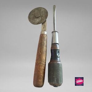 May include: A vintage pizza cutter with a wooden handle and a metal wheel, and a vintage screwdriver with a wooden handle and a metal shaft.