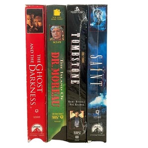 Puede incluir: Cuatro cintas VHS: "The Ghost and the Darkness" en rojo, "The Island of Dr. Moreau" en verde, "Tombstone" en negro y "The Saint" en azul. Cada cinta tiene títulos e imágenes de películas. Las cintas están selladas en plástico.