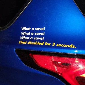 May include: A blue car with a sticker that says "What a save!" repeated three times, followed by "Chat disabled for 3 seconds." The car's taillight is visible.