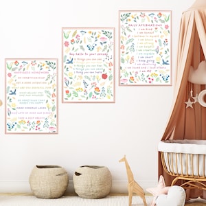 May include: Three framed prints with colorful floral borders and inspirational text. The prints are hung on a white wall in a nursery setting. The text on the prints reads "Happiness Homework", "Say hello to your senses", and "Daily Affirmations".