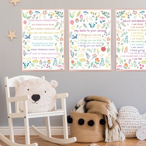 May include: Three colorful printable posters with floral designs and inspirational messages. The first poster says "Happiness Homework" and includes phrases like "Do something kind", "Set a good intention", and "Take a deep breath". The second poster says "Say hello to your senses" and lists five things you can do with each sense. The third poster says "Daily Affirmations" and includes phrases like "I am kind", "I am honest", and "I am loved".