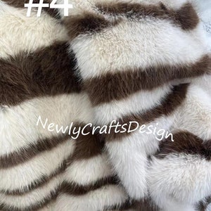 May include: A close-up of a white and brown striped faux fur fabric. The fabric has a soft, fluffy texture and is perfect for crafting projects. The text "#4 NewlyCraftsDesign" is visible in the image.
