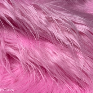 May include: Close-up of a soft, pink faux fur fabric. The fur is long and fluffy, with a subtle sheen. #9451 NewlyCraftsDesign