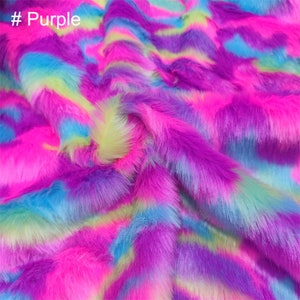 May include: Close-up of a soft, fluffy fabric with a colorful, abstract pattern in shades of pink, blue, purple, and green. The fabric has a fuzzy, plush texture. #Purple