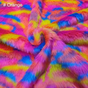 May include: A close-up of a bright pink, blue, and yellow faux fur fabric with a tie-dye pattern. The fabric is soft and fluffy, and it would be perfect for making a variety of crafts.