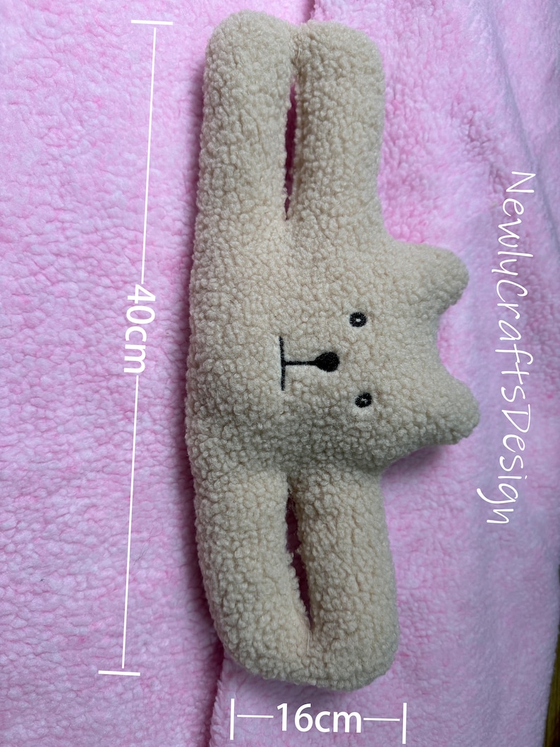 May include: A beige plush toy shaped like a bear with a black nose and eyes. The toy is 16 inches wide and 40 inches tall.  "NewlycraftsDesign" is written on the right side of the image.