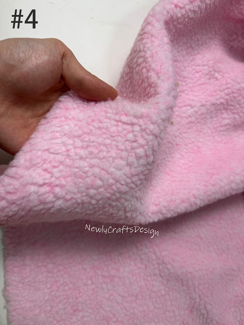 May include: Close-up of a soft, pink, fuzzy fabric. The fabric has a textured, fluffy surface.