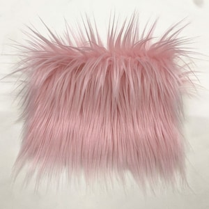 May include: A close-up of a pink fluffy fabric. The fabric has a soft, plush texture and is perfect for crafting projects.