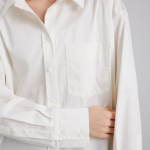 Pu&ograve; includere: Una camicia bianca a maniche lunghe con bottoni, una tasca sul petto e polsini con bottoni.