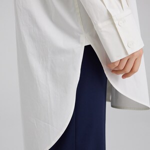 Pu&ograve; includere: Una camicia bianca a maniche lunghe con un orlo arrotondato e un polsino abbottonato. La camicia &egrave; realizzata in un tessuto leggero e ha una vestibilit&agrave; rilassata.