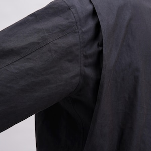 K&ouml;nnte beinhalten: Nahaufnahme eines schwarzen Langarmshirts. Das Bild zeigt die Schulter- und &Auml;rmeldetails und pr&auml;sentiert die Textur und die N&auml;hte des Stoffes. Das Shirt scheint aus einem leichten Material zu sein.