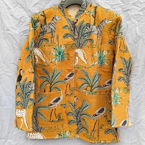 May include: A mustard yellow quilted jacket featuring a repeating print of zebras, leopards, and long-legged birds amidst green palm leaves. The jacket has a mandarin collar, long sleeves, two front patch pockets, and a vertical row of buttons.