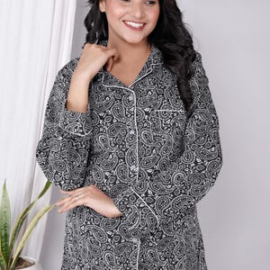 Könnte beinhalten: Schwarzer und weißer Paisley-Druck-Pyjama-Oberteil mit Knopfleiste und langen Ärmeln.