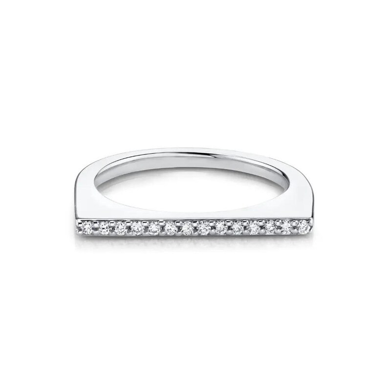 Puede incluir: Un anillo de tono plateado con una barra horizontal plana en la parte superior. La superficie frontal de esta barra est&aacute; incrustada con una fila &uacute;nica de peque&ntilde;as piedras claras de corte redondo que abarcan todo el ancho de la secci&oacute;n plana.