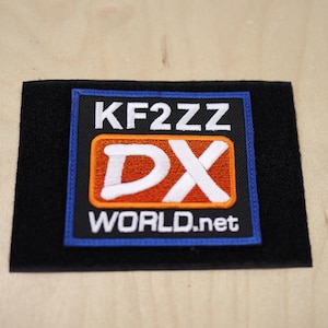 May include: Black patch with blue border, featuring white text "KF2ZZ DX WORLD.net" with a white "DX" in an orange rectangle.