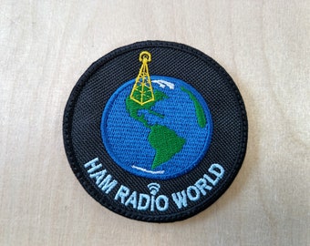 Könnte beinhalten: Schwarzer gestickter Aufnäher mit einem blauen und grünen Globus, einer gelben Antenne und dem Text "HAM RADIO WORLD".