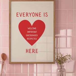 Może przedstawiać: Oprawiony wydruk z czerwonymi słowami "EVERYONE IS HERE", z czerwonym sercem pośrodku zawierającym słowa "WELCOME, IMPORTANT, ENCOURAGED, RESPECTED". Rama jest jasnobrązowa, na tle r&oacute;żowej kafelkowej ściany.