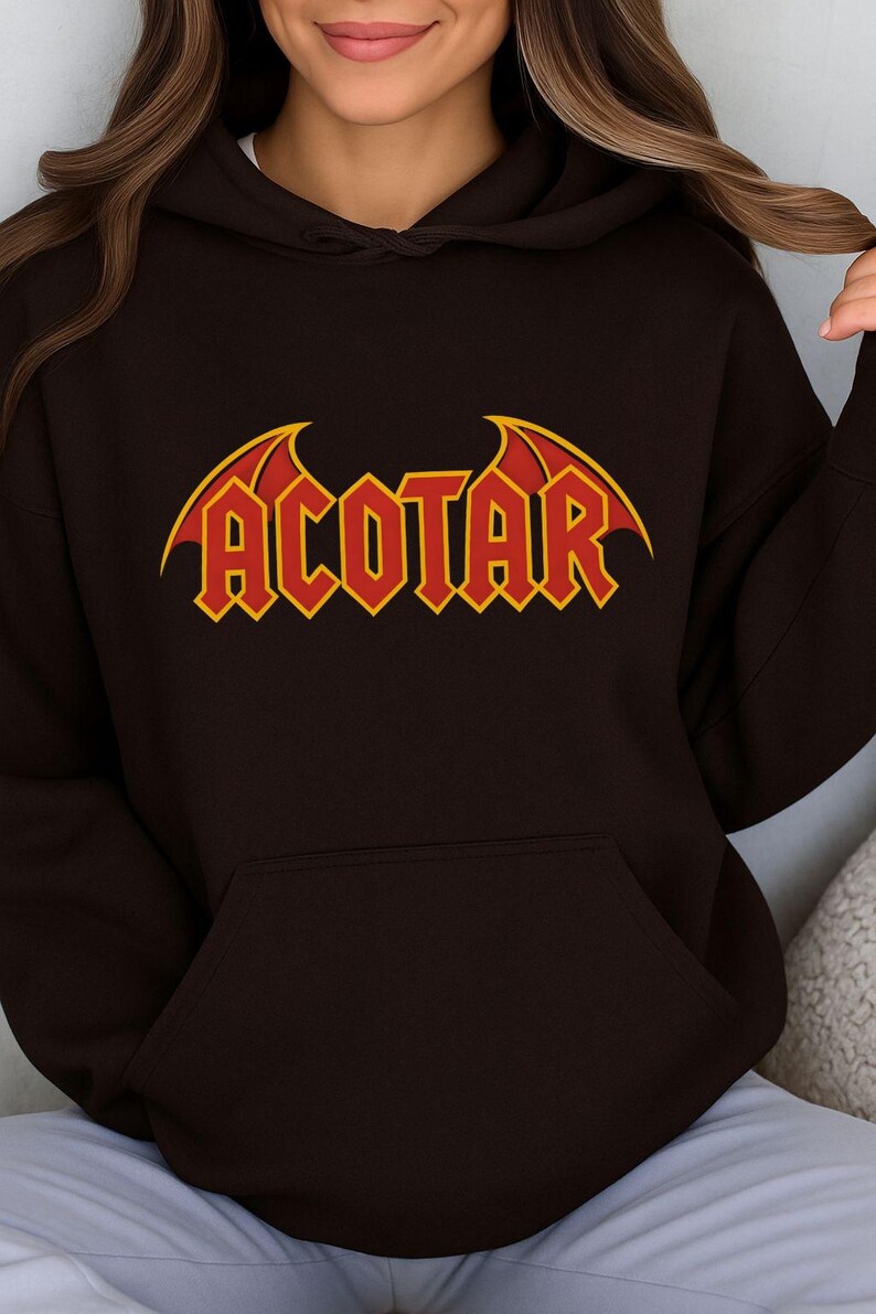 May include: A dark brown hoodie with a front pocket and a hood. The word "ACOTAR" is printed across the chest in red block letters with yellow accents and bat-wing designs.
