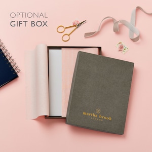 A martha brook branded optional gift box. The gift box is grey in colour and has the martha brook logo on the lid at the bottom centre,