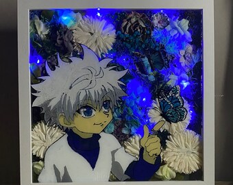 May include: A white framed shadow box featuring a blue and white anime character, flowers, and a butterfly. The box is illuminated with blue LED lights.